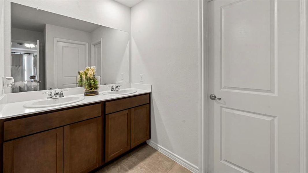 Bathroom featuring double vanity and light tile patterned floors
