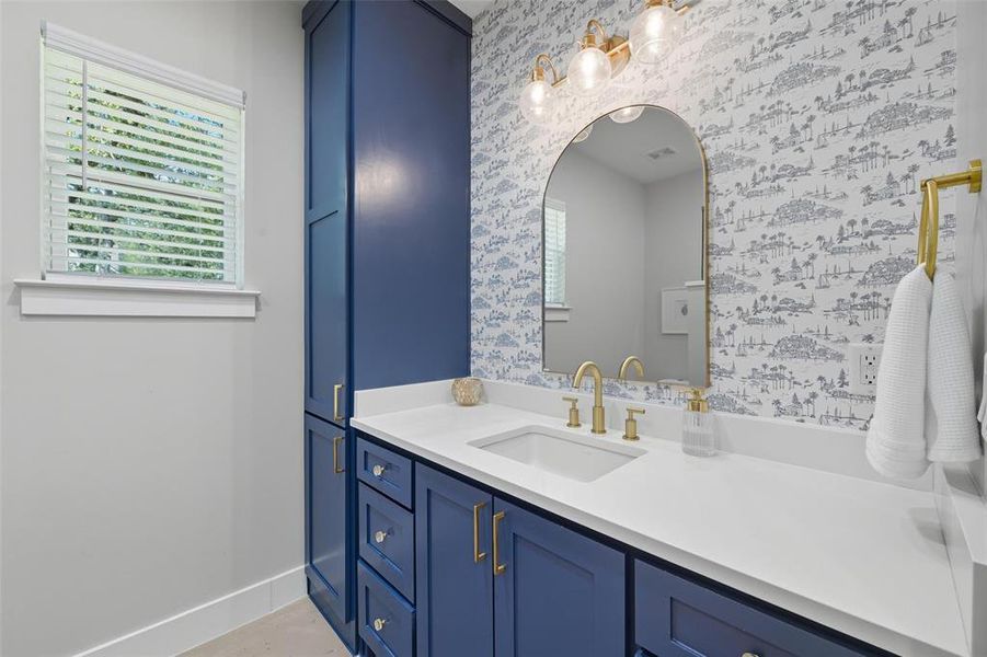 Bathroom with vanity and wallpapered walls Bathroom with vanity and wallpapered walls