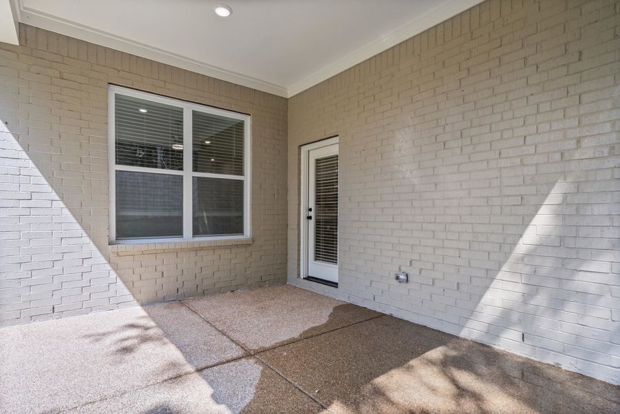 Doorway to property featuring a patio area and brick siding