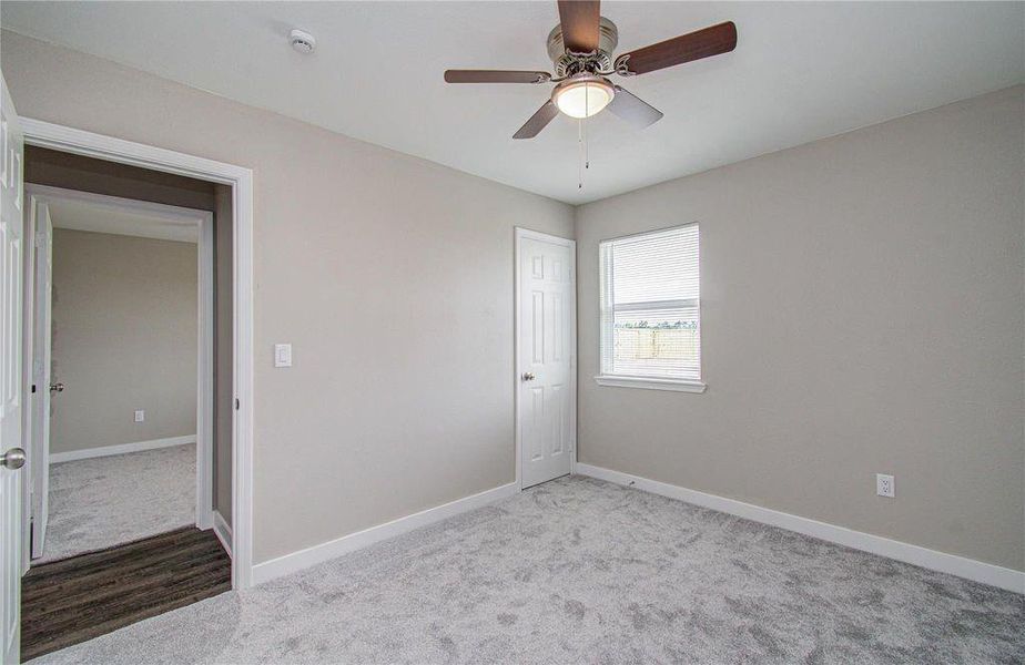 Bedroom 1 view to hallway. Updated carpet, light fixtures and private closet and view to large backyard.