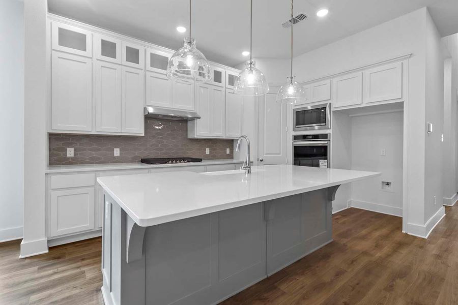 Kitchen featuring decorative backsplash, white cabinets, appliances with stainless steel finishes, dark wood-style floors, and recessed lighting Kitchen featuring decorative backsplash, white cabinets, appliances with stainless steel finishes, dark wood-style floors, and recessed lighting