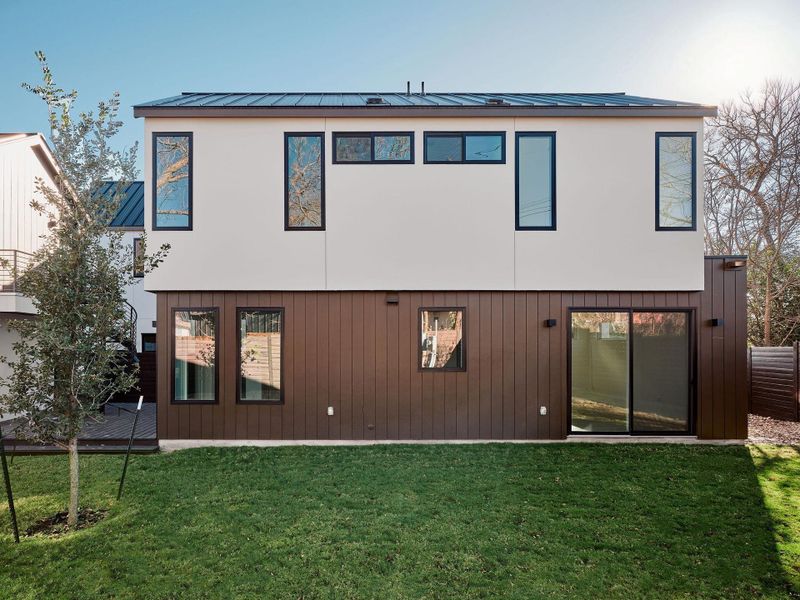 Rear view of house with a yard, a metal roof, and a deck