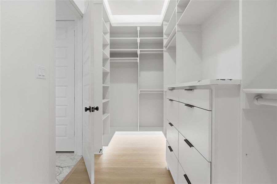 Custom closet organization system featuring white cabinetry and shelving