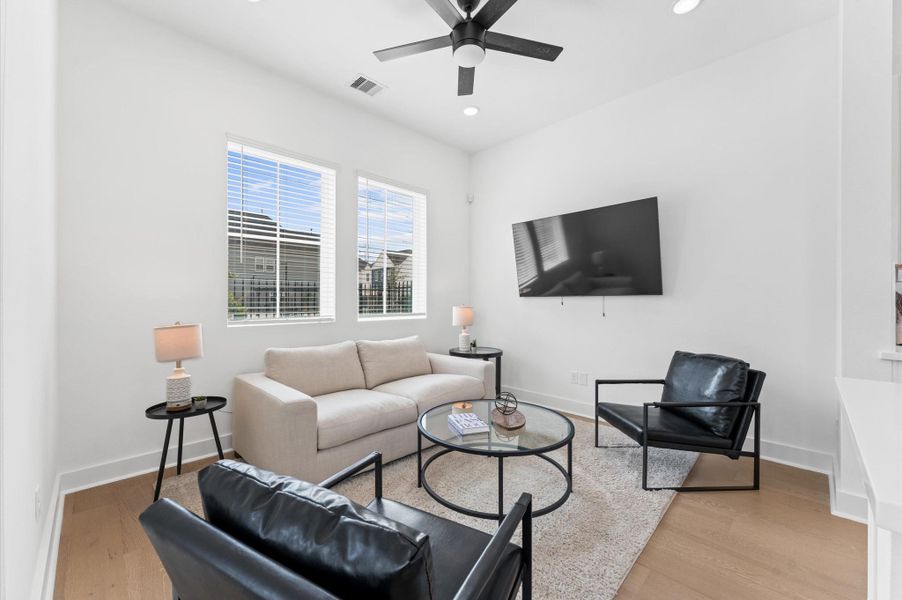 Bathed in natural light, this inviting living area offers serene views of the beautifully landscaped community courtyard creating a seamless connection between indoor comfort and outdoor charm.