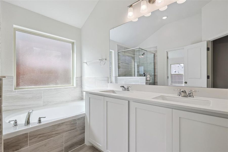 Bathroom with independent shower and bath, vanity, and vaulted ceiling