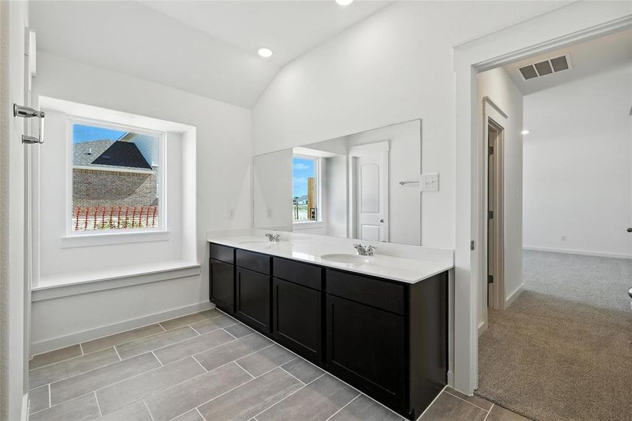 Full bath with double vanity, lofted ceiling, and recessed lighting Full bath with double vanity, lofted ceiling, and recessed lighting