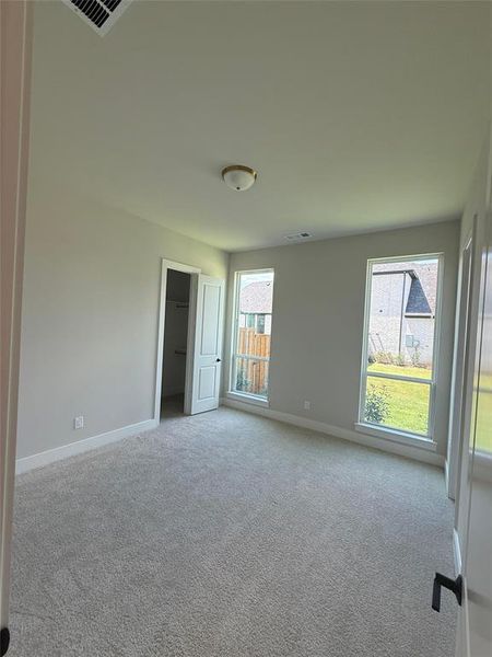 Empty room featuring light colored carpet and baseboards Empty room featuring light colored carpet and baseboards