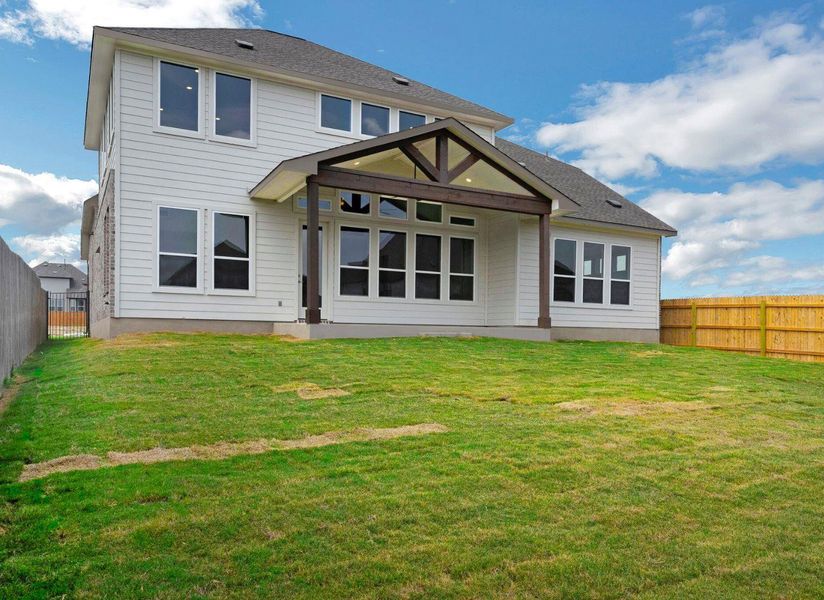 Rear view of house with a fenced backyard and a lawn Rear view of house with a fenced backyard and a lawn