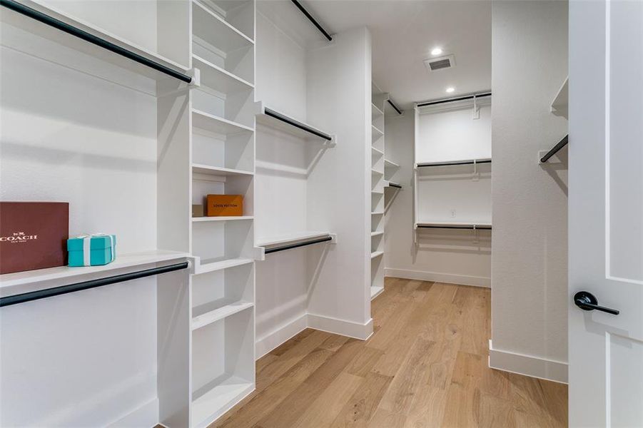 Walk in closet with light wood-style floors