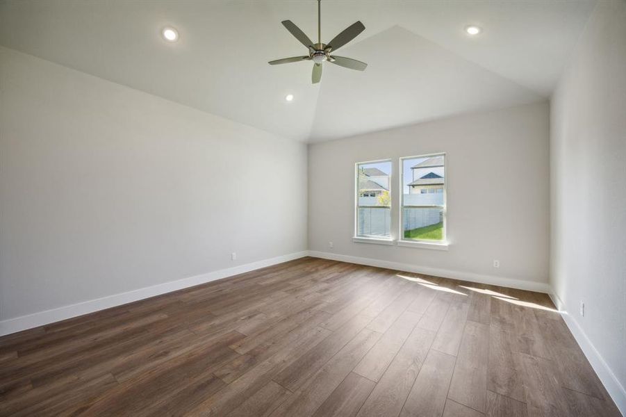 Unfurnished room featuring hardwood / wood-style flooring, ceiling fan, and high vaulted ceiling