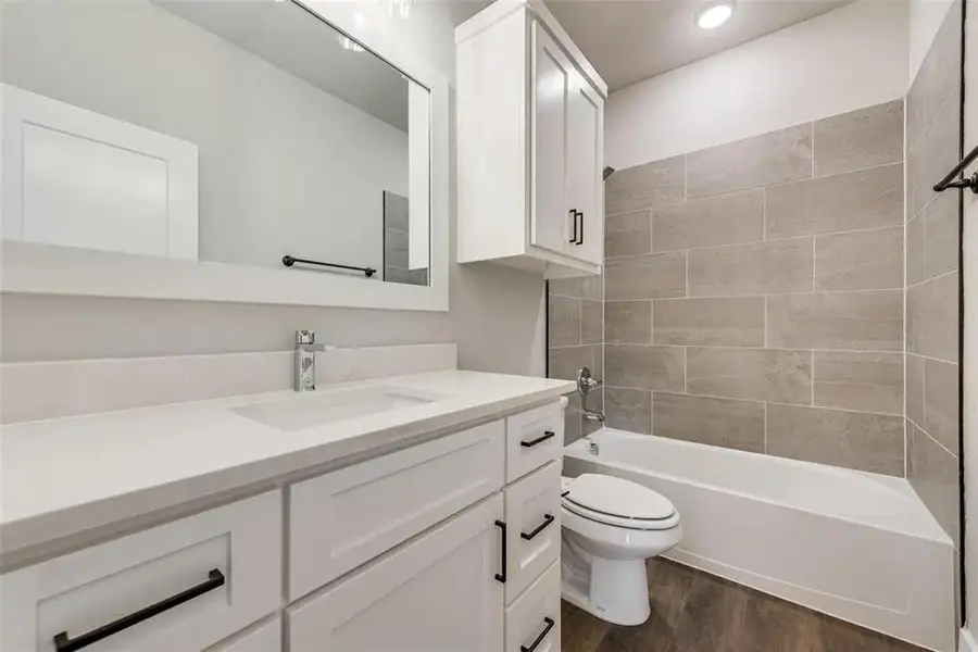 Full bath featuring vanity, shower / bathtub combination, and dark wood-style flooring