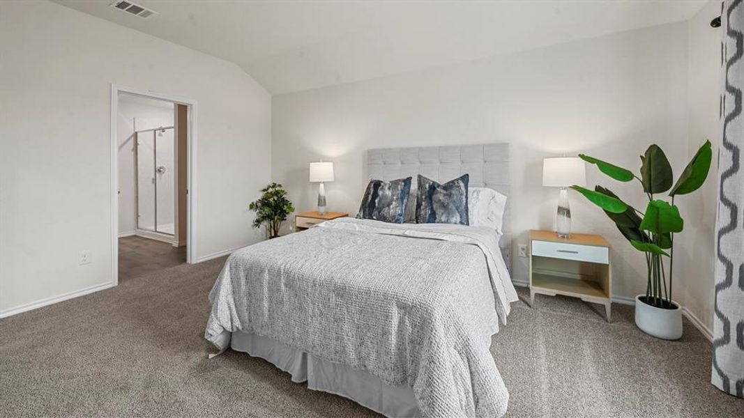 Carpeted bedroom featuring vaulted ceiling and ensuite bath Carpeted bedroom featuring vaulted ceiling and ensuite bath