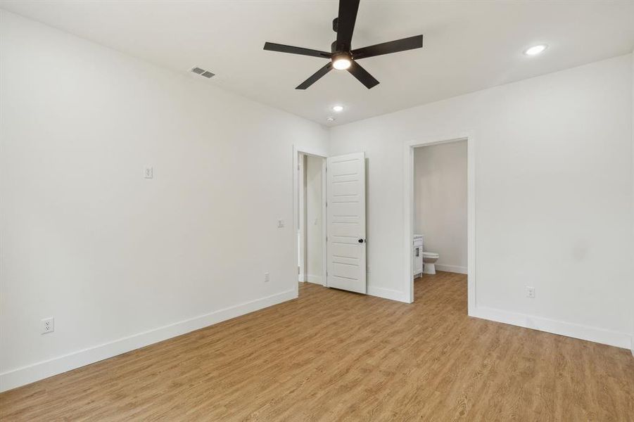 Unfurnished bedroom with ceiling fan, light hardwood / wood-style floors, and connected bathroom