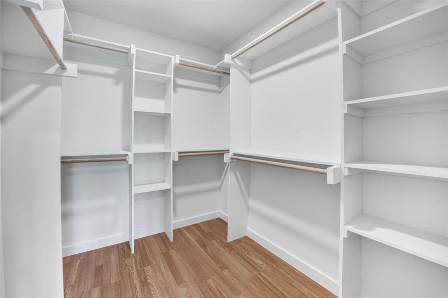 Spacious closet featuring light wood-style flooring Spacious closet featuring light wood-style flooring