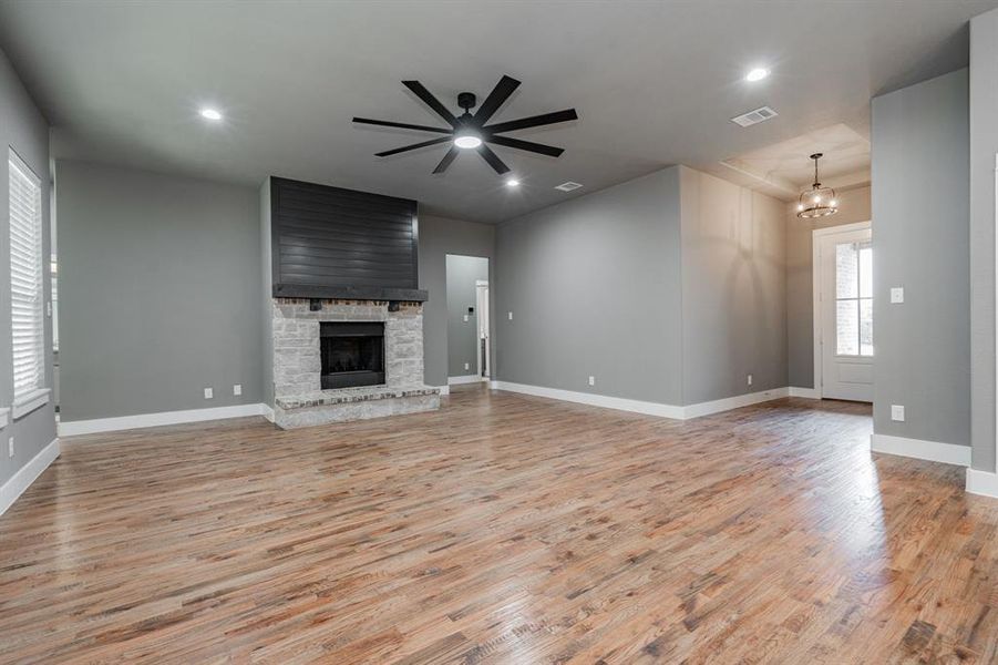 Unfurnished living room with baseboards, light wood-type flooring, and visible vents Unfurnished living room with baseboards, light wood-type flooring, and visible vents