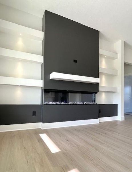 Unfurnished living room with wood finished floors and baseboards