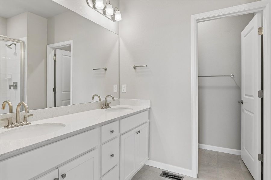 A bathroom with a sink and a shower unit.