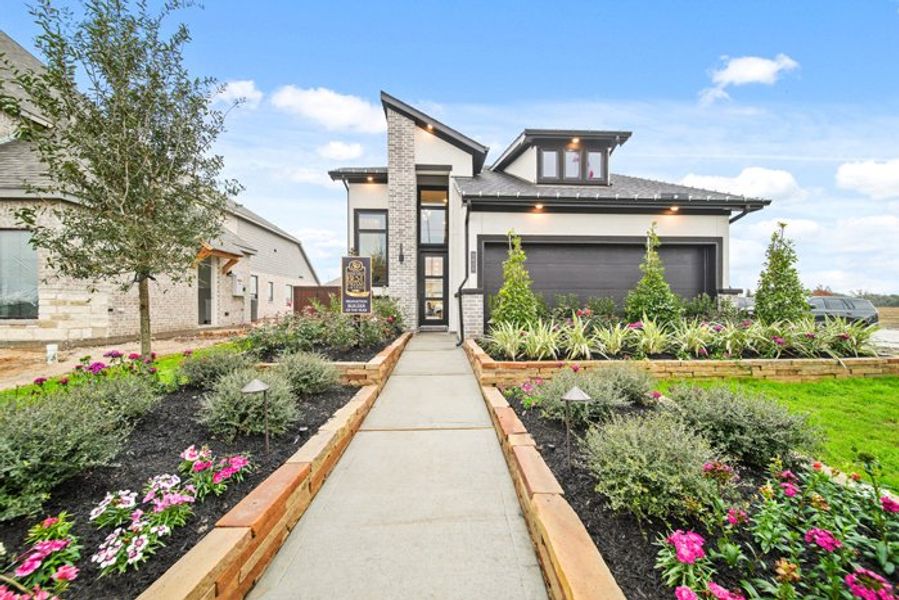 Front exterior of a new home in Meridiana 40', 65', Iowa Colony, TX, highlighting curb appeal (Image 2).