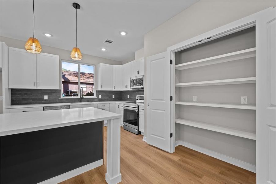 Large pantry with easy access to the kitchen and island.