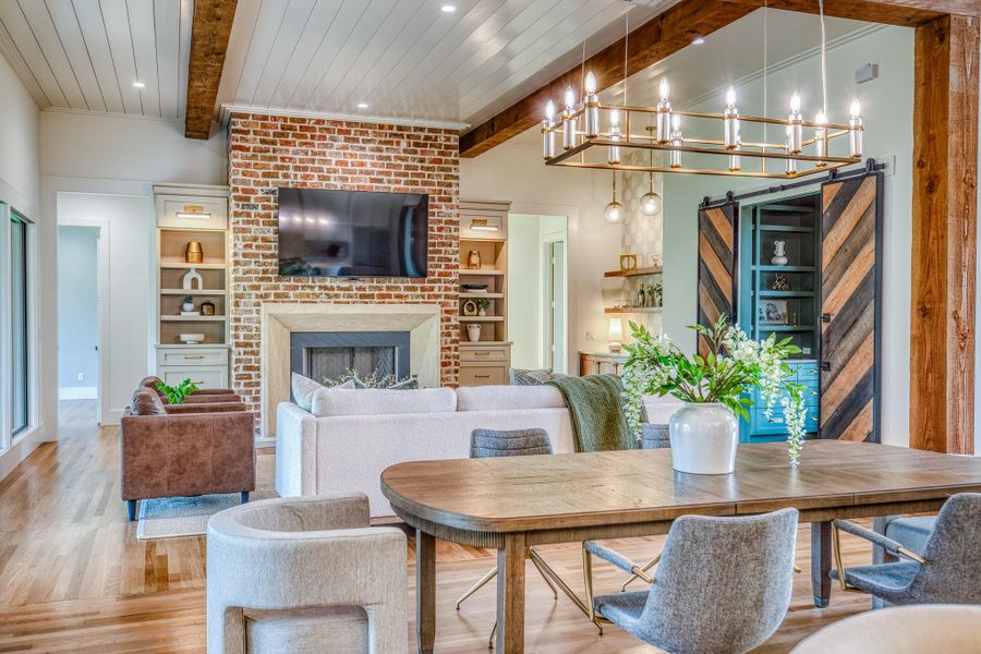 Dining area featuring a fireplace, beam ceiling, wood finished floors, and recessed lighting Dining area featuring a fireplace, beam ceiling, wood finished floors, and recessed lighting