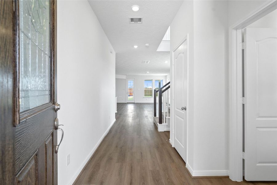 Welcome to your new home at 5619 Sanderling Circle. You are greeted with this beautiful entryway featuring gorgeous vinyl plank flooring, recessed lighting and custom paint. The front door is an 8' Texas Star Glass Door with brushed nickel finish and in dark walnut stain.