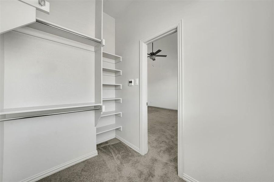 Walk in closet with light carpet and a ceiling fan Walk in closet with light carpet and a ceiling fan