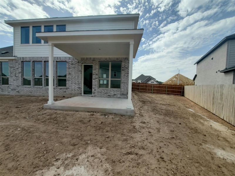 Back of house featuring brick siding, a patio, and a fenced backyard