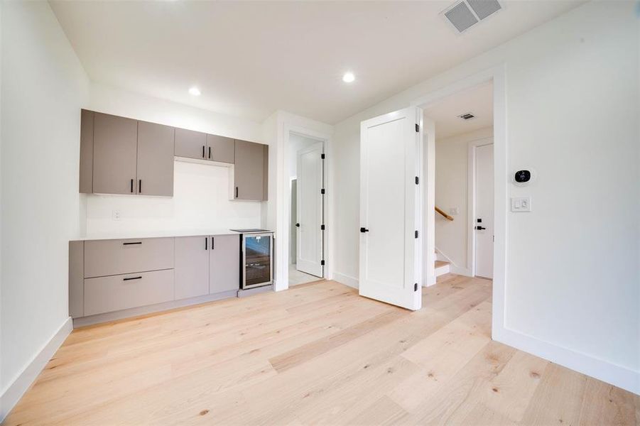 Kitchen featuring gray cabinets, light hardwood / wood-style floors, and wine cooler