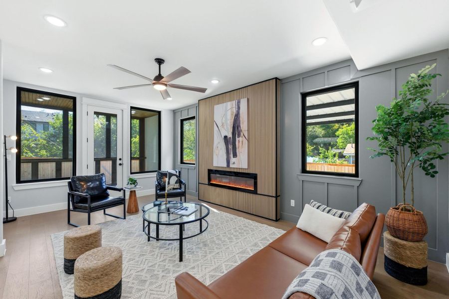 Living area with wood finished floors, a fireplace, ceiling fan, healthy amount of natural light, and recessed lighting Living area with wood finished floors, a fireplace, ceiling fan, healthy amount of natural light, and recessed lighting