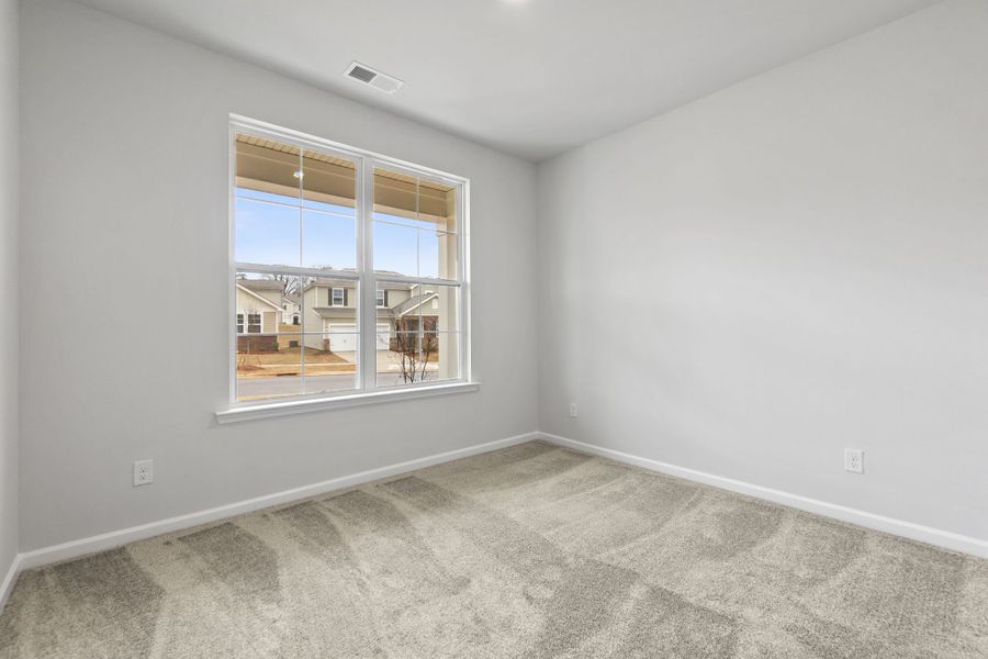 A room with a window and a white wall with a view of a city.