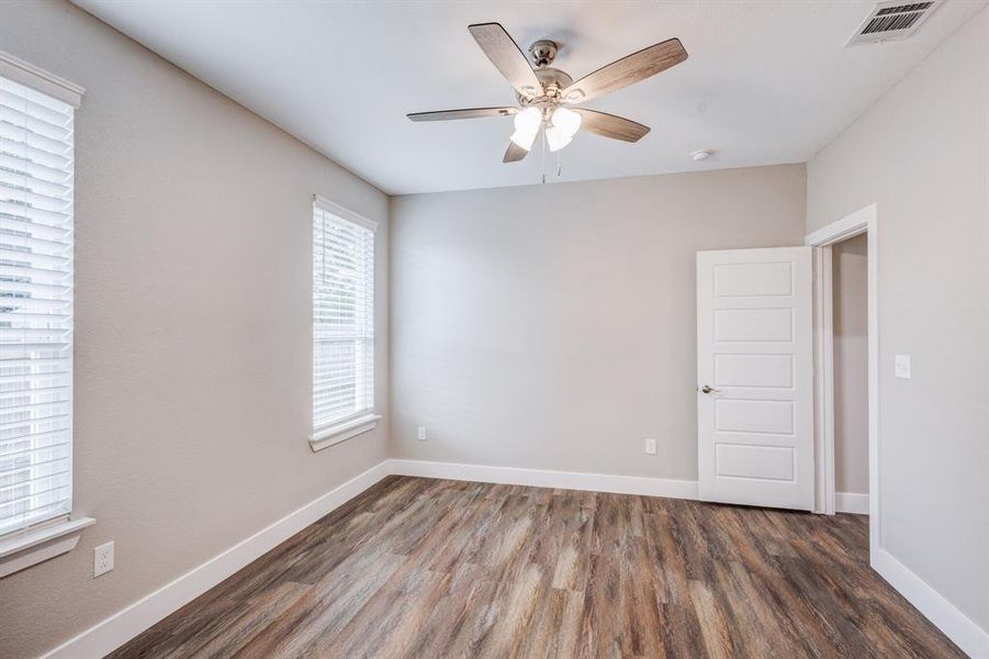 Empty room with hardwood / wood-style floors and ceiling fan