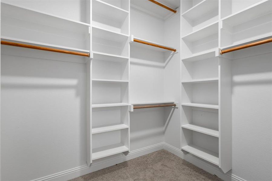 Primary Walk-in Closet with custom shelves and racks