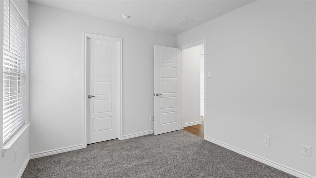 Unfurnished bedroom featuring carpet and baseboards