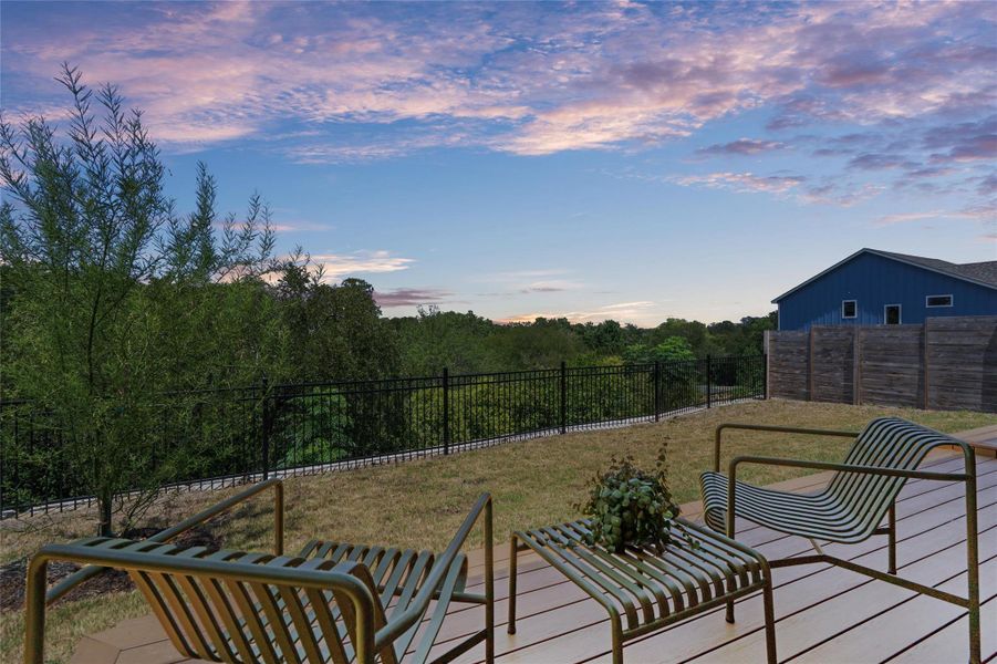 An inviting deck overlooks a fenced yard and verdant tree line, offering scenic outdoor living. An inviting deck overlooks a fenced yard and verdant tree line, offering scenic outdoor living.