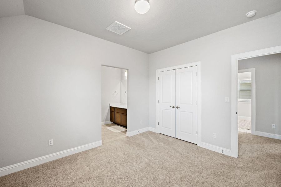 Unfurnished bedroom featuring connected bathroom, light colored carpet, visible vents, and baseboards Unfurnished bedroom featuring connected bathroom, light colored carpet, visible vents, and baseboards