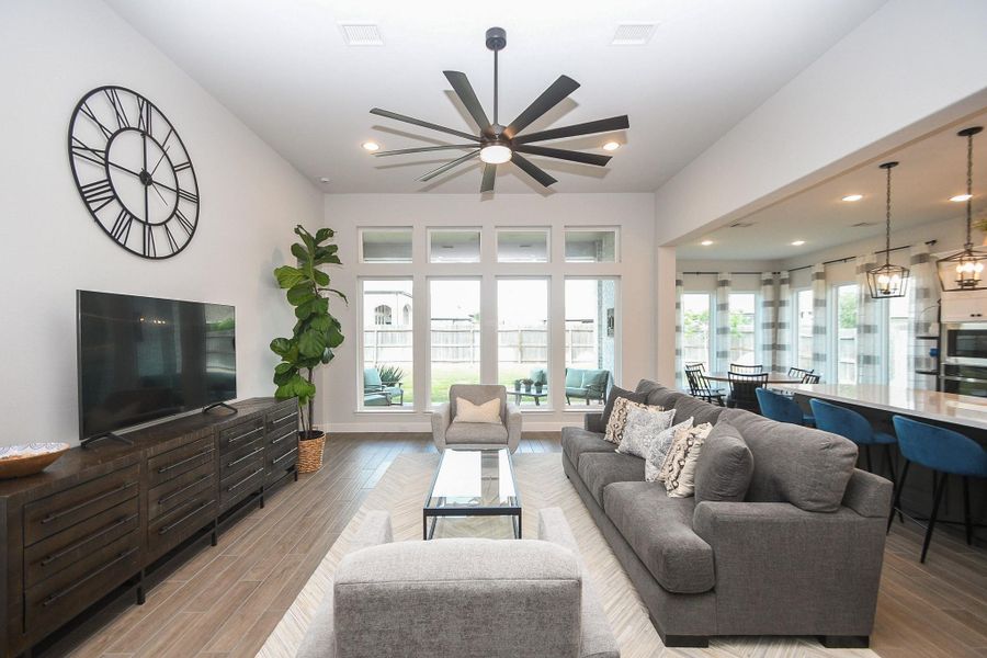 Open concept living with a wall of windows overlooking backyard