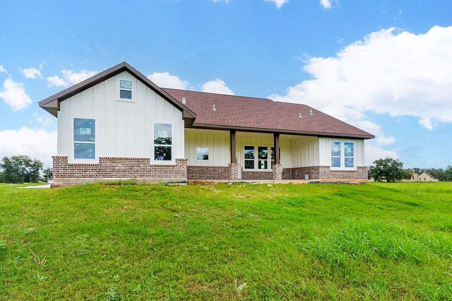 Charming single-story home with a blend of brick and siding exterior, featuring a spacious covered patio overlooking lush green surroundings. Charming single-story home with a blend of brick and siding exterior, featuring a spacious covered patio overlooking lush green surroundings.