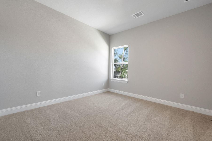Empty room with light colored carpet and baseboards