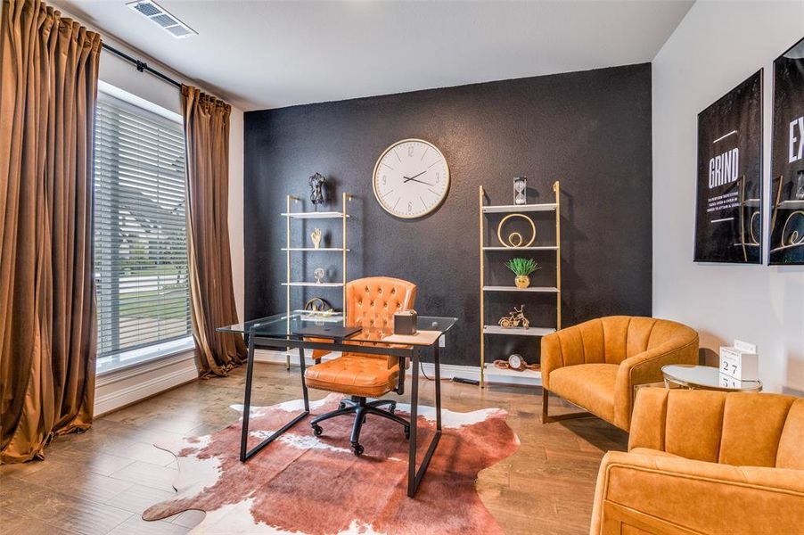 Office area with wood finished floors and a textured wall