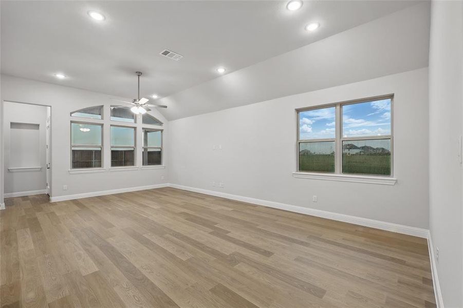 Empty room with ceiling fan, lofted ceiling, light wood-type flooring, and recessed lighting Empty room with ceiling fan, lofted ceiling, light wood-type flooring, and recessed lighting