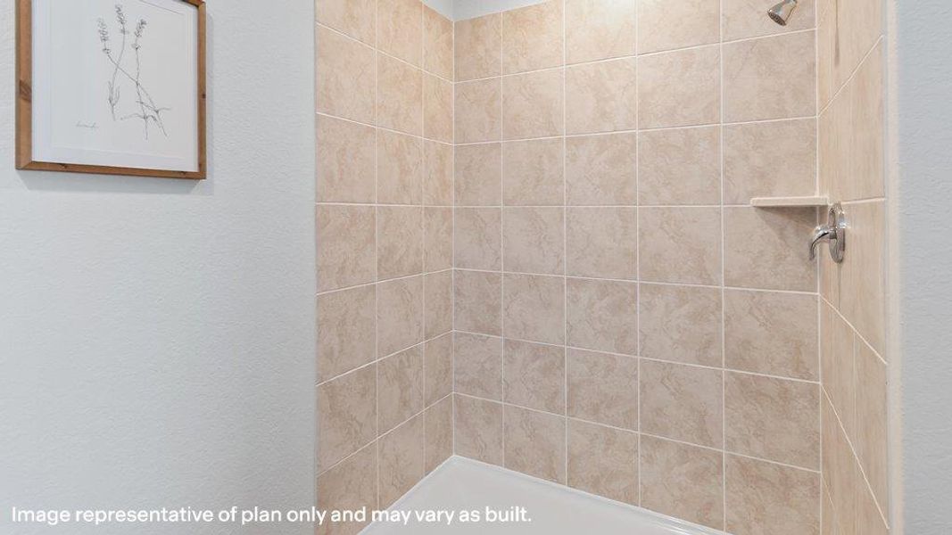 A pristine shower area featuring neutral-toned tile walls and a built-in soap shelf. A pristine shower area featuring neutral-toned tile walls and a built-in soap shelf.