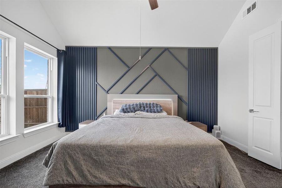 Bedroom with vaulted ceiling, carpet floors, and ceiling fan Bedroom with vaulted ceiling, carpet floors, and ceiling fan