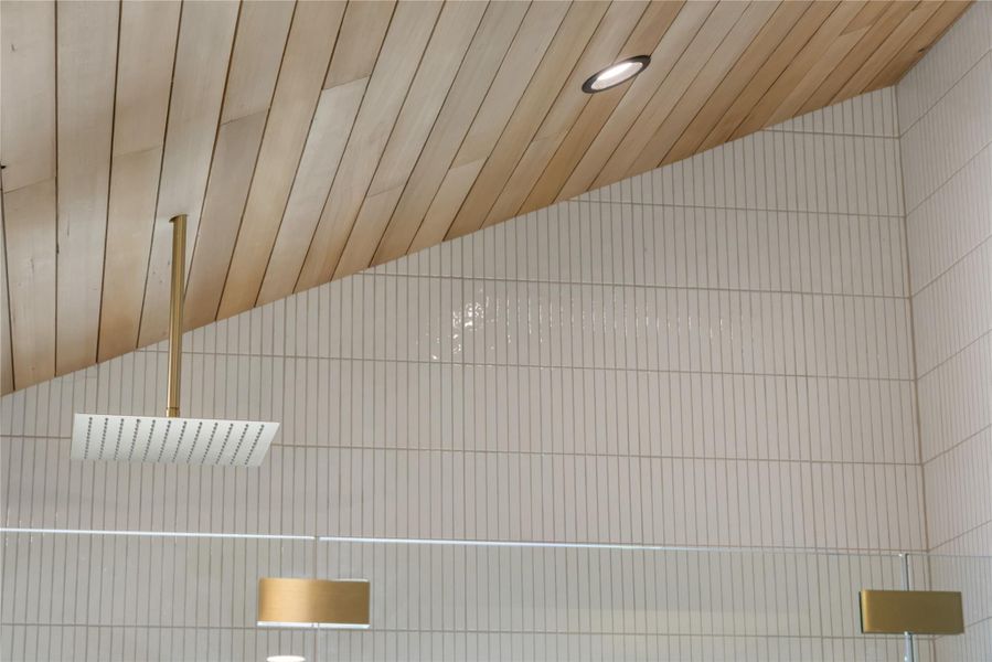Bathroom view of a relaxing sauna, tiled shower, and recessed lighting