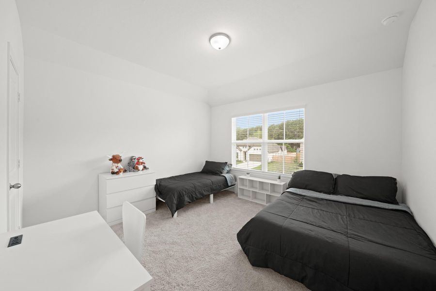 This spacious, seconary bedroom enjoys a large window and a walk-in closet.