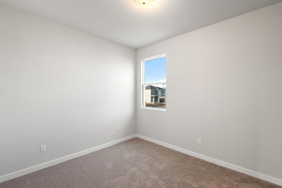 Carpeted spare room featuring baseboards