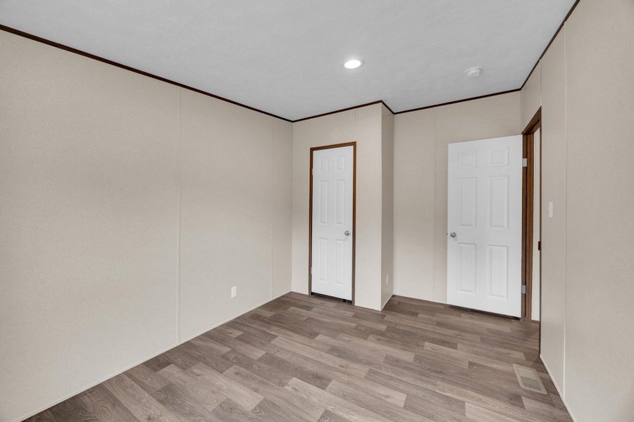 Unfurnished bedroom featuring light wood-type flooring, recessed lighting, crown molding, and a closet