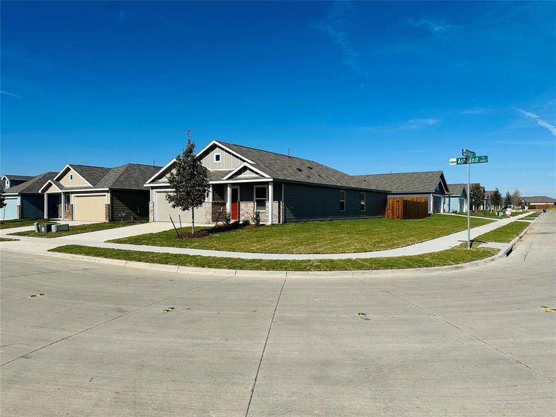 Single story home with a garage and a front lawn