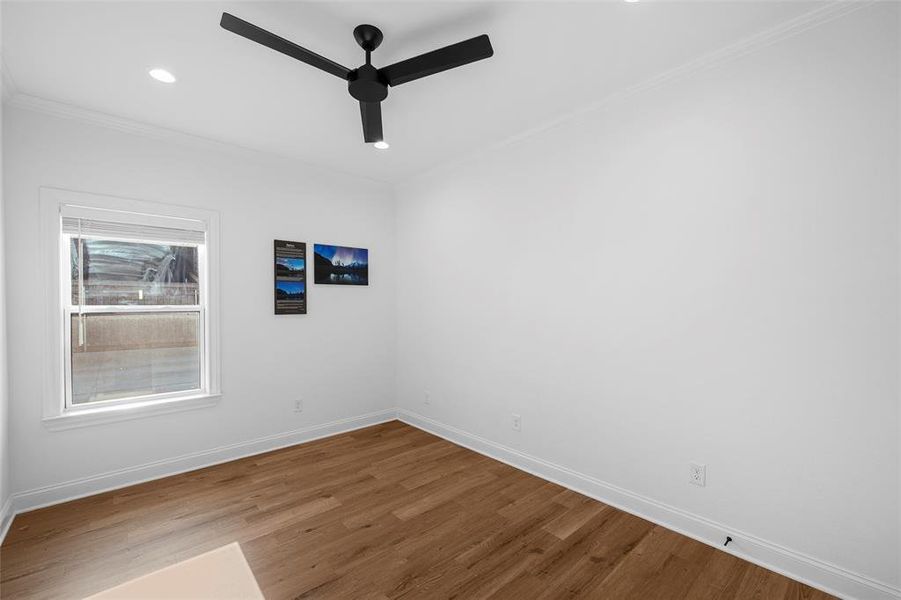 Spare room with wood finished floors, recessed lighting, ceiling fan, and crown molding Spare room with wood finished floors, recessed lighting, ceiling fan, and crown molding