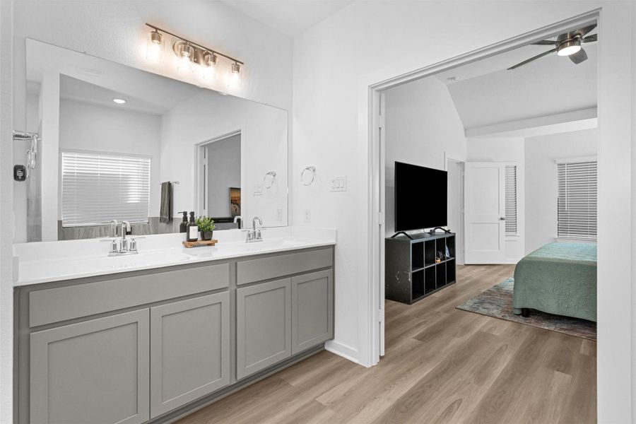 This angle highlights the wide countertop, sleek cabinetry, and easy flow into the primary suite, creating a bright and well-designed space for daily routines.