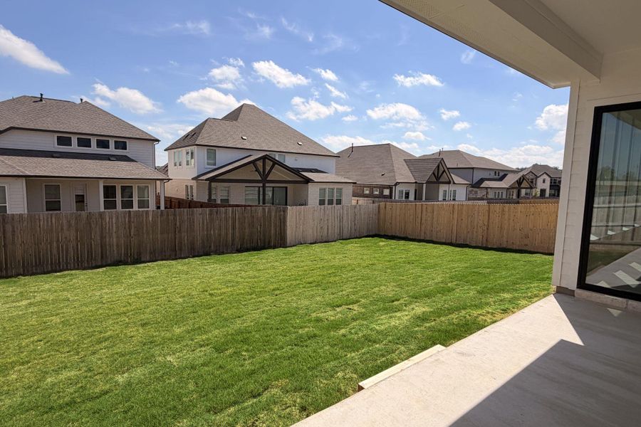 Fenced backyard featuring a residential view and a patio area